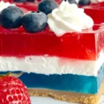 4th of July Patriotic Jello Pie: A No-Bake Red, White & Blue Treat 9 Close-up of 4th of July Patriotic Jello Pie with red, white, and blue layers, whipped cream topping, and fresh berries in a graham cracker crust.