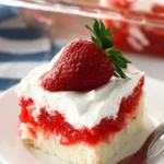 Slice of strawberry Jello poke cake with Cool Whip topping and fresh strawberry garnish on a white plate.