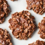 Delicious No Bake Cookies — Easy Recipes for Every Taste 7 Close-up of homemade no bake cookies with chocolate and oats on beige linen cloth, showing rich texture and glossy coating.