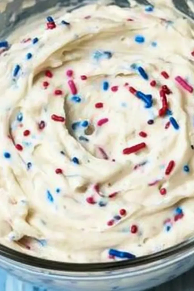 Red White and Blue Funfetti Dip – Easy No-Bake Party Treat 13 Red, white, and blue sprinkles folded into creamy funfetti dip in a glass bowl.