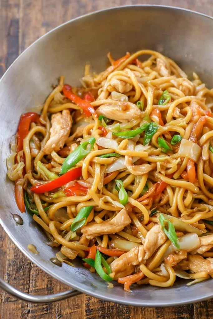 Final dish of Super Easy Chicken Lo Mein served in a wok with sauced noodles, chicken, and vegetables.