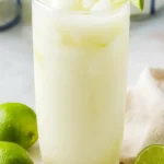 Brazilian Lemonade: Delicious, Creamy & Refreshing Drink 5 Glass of Brazilian Lemonade with ice and lime slices, served on marble with fresh lime halves.