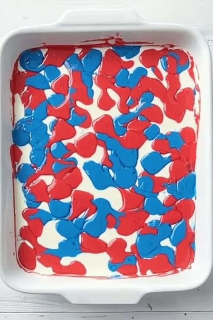 Patriotic Poke Cake: The Ultimate 4th of July Dessert 11 Red, white, and blue cake batter layered in a baking dish for Patriotic Poke Cake