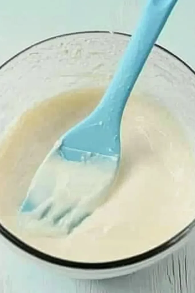 Patriotic Poke Cake: The Ultimate 4th of July Dessert 9 Bowl of white cake batter with silicone spatula for Patriotic Poke Cake
