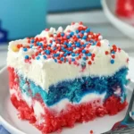 Patriotic Poke Cake: The Ultimate 4th of July Dessert 13 Slice of Patriotic Poke Cake with red, white, and blue layers, topped with whipped cream and sprinkles on a plate.
