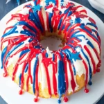 Easy Red White and Blue Cake: A Patriotic Treat for July 4th 5 Red white and blue bundt cake topped with patriotic frosting and star sprinkles on a white plate.