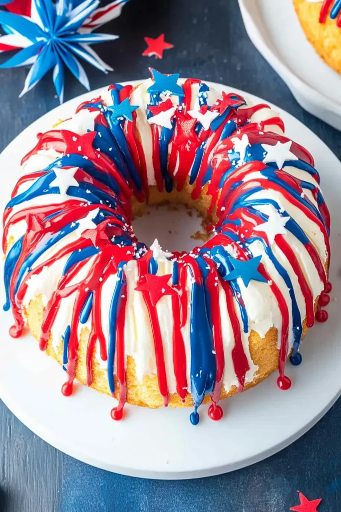Red white and blue bundt cake topped with patriotic frosting and star sprinkles on a white plate.