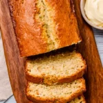 Southern Peach Bread: Easy Moist Recipe for Summer Baking 7 Moist sliced Southern peach bread on a wooden board with butter spread on the side.