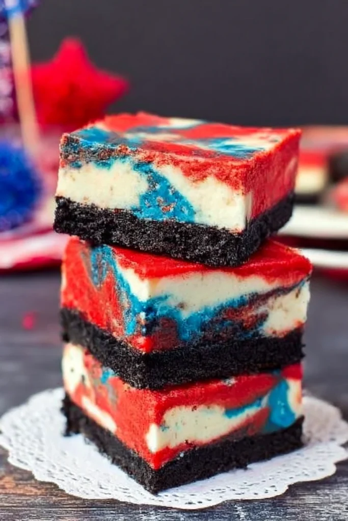 Red White and Blue Cheesecake Bars: Easy Patriotic Dessert for 4th of July 5 Stack of four red, white, and blue swirled cheesecake bars with Oreo crust, displayed on a white doily and plate, perfect for 4th of July celebrations