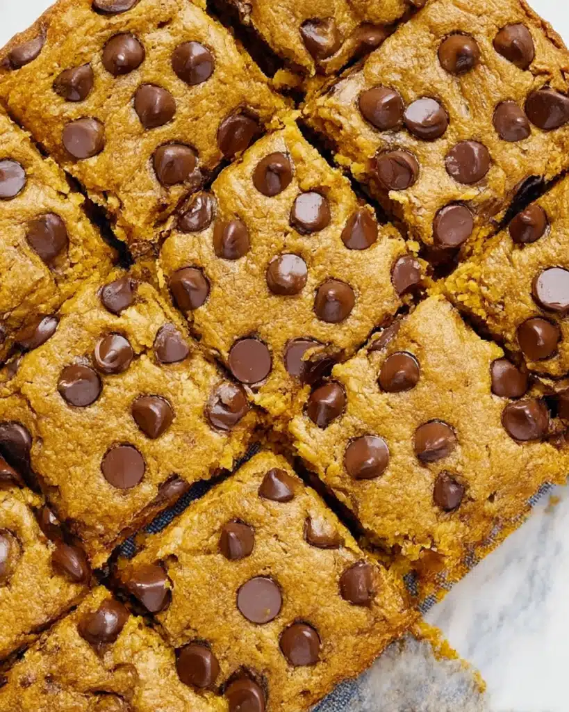 Pumpkin Chocolate Chip Bars – Easy, Moist, and Flavor-Packed 8 Angled view of moist pumpkin chocolate chip bars cut into squares with melted chocolate chips on top