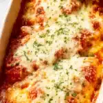 Cheesy Mozzarella Chicken Bake – Easy, Juicy & Irresistible 15 Cheesy mozzarella chicken bake in a creamy tomato sauce, topped with golden melted cheese and fresh basil in a baking dish