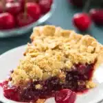 Cherry Crumble Pie – Buttery, Juicy, and Easy to Make 12 Close-up of a cherry crumble pie slice with golden oat topping and juicy cherry filling on a white plate