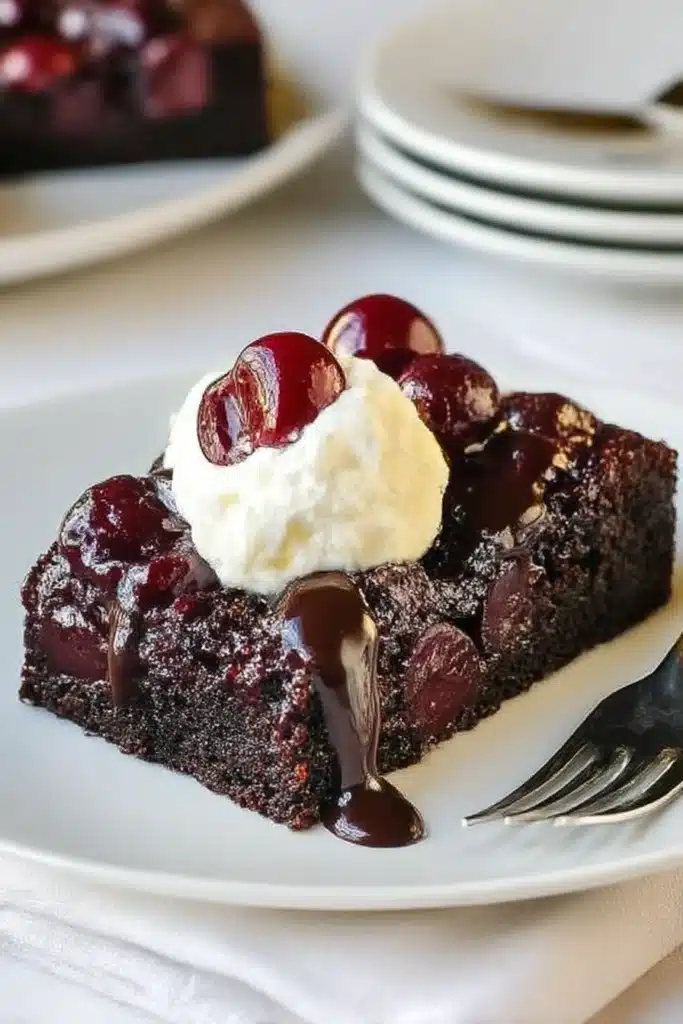 Chocolate Cherry Upside Down Cake – Deliciously Easy & Moist Midweek Treat! 6 Chocolate Cherry Upside Down Cake slice with whipped cream and ganache on a plate with elegant table setting.