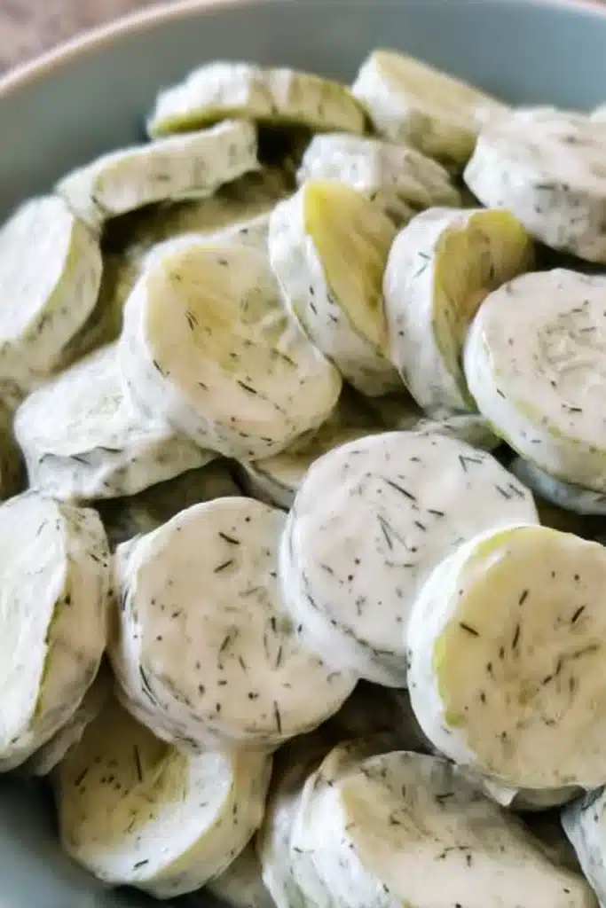 Close-up of creamy cucumber salad with dill dressing on sliced cucumbers