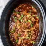 Crock Pot Bourbon Chicken – Sweet, Sticky & Comforting Slow Cooker Classic 9 Crock Pot Bourbon Chicken simmering in a slow cooker, shredded and coated in sticky sweet sauce, garnished with green onions.