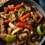 Crockpot Pepper Steak – Easy, Flavorful Slow Cooker Favorite 9 Crockpot pepper steak with bell peppers and onions in a savory brown sauce, served in a rustic bowl