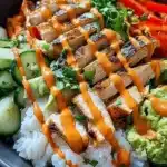 Bang Bang Chicken Bowl: Ultimate Comfort Food for Busy Nights 6 Bang Bang Chicken Bowl with grilled chicken, spicy mayo sauce, rice, and fresh vegetables in a black bowl