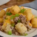 Slow Cooker Cowboy Casserole Recipe for Cozy Dinners 6 Slow Cooker Cowboy Casserole topped with golden tater tots, creamy ground beef filling, melted cheese, and green onions.