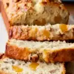 Peach Pecan Bread Recipe – Sweet, Moist, and Perfect for Summer 8 Moist peach pecan bread sliced on a plate, showing chunks of peaches and pecans in a golden crust.