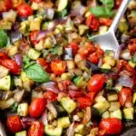 Mediterranean Roasted Eggplant – Easy Vegan Side Dish 9 Mediterranean roasted eggplant with zucchini, cherry tomatoes, red onion, and basil on a baking tray