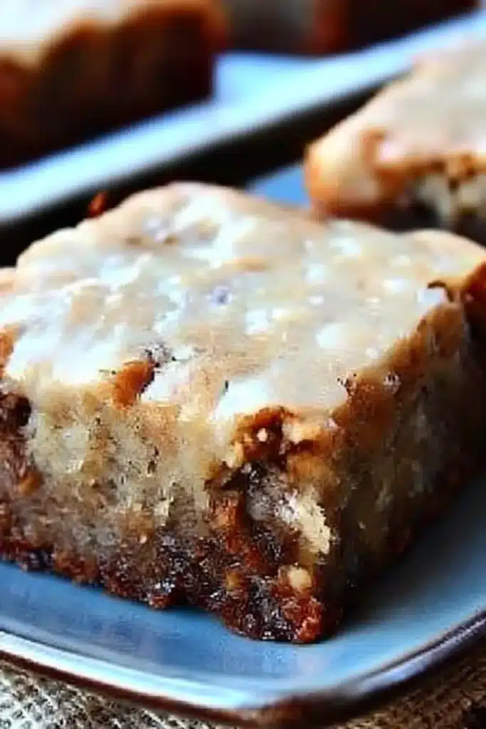 Close-up of banana bread brownie with brown butter frosting on a ceramic plate

