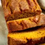 Pumpkin Bread Recipe: Moist, Sweet & Easy to Make 9 Sliced homemade pumpkin bread with a crispy sugar crust and soft moist crumb on parchment paper.