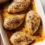 Juicy Baked Chicken Breast – Easy, Flavorful, and Perfect Every Time 8 Juicy baked chicken breasts in a ceramic dish with golden seasoning and rich pan juices.