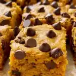 Pumpkin Chocolate Chip Bars – Easy, Moist, and Flavor-Packed 9 Moist pumpkin chocolate chip bars with melty chocolate chunks, sliced and ready to serve on a rustic surface