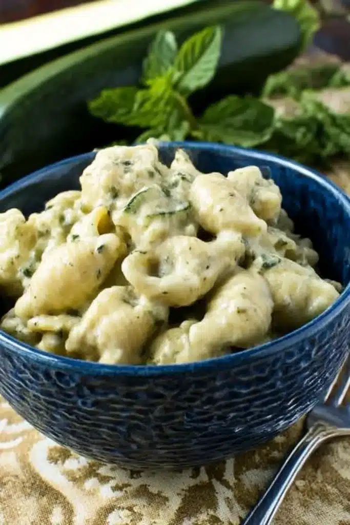 Creamy Zucchini Sauce Recipe – Rich & Lusciously Smooth 11 Bowl of creamy shell pasta with zucchini sauce on patterned cloth with fresh herbs