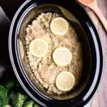 Slow Cooker Lemon Pepper Chicken with Rice – Easy One-Pot Dinner 5 Slow cooker lemon pepper chicken with rice topped with lemon slices, served next to broccoli and rustic kitchen tools.