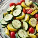 Zucchini And Summer Squash Salad with Herby Vinaigrette 5 Fresh zucchini and summer squash salad with cherry tomatoes and herbs in a bowl