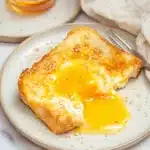 Air Fryer Egg and Cheese Toast | Crispy & Quick Favorite 5 Air fryer egg and cheese toast with runny yolk and melted mozzarella on a white plate with fork and syrup