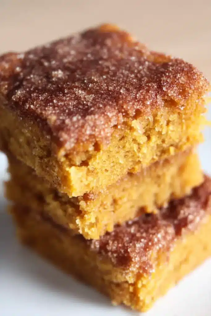 Pumpkin Snickerdoodle Snack Cake: Simple & Delicious 9 Stacked squares of baked pumpkin snickerdoodle cake with crackly cinnamon sugar topping.