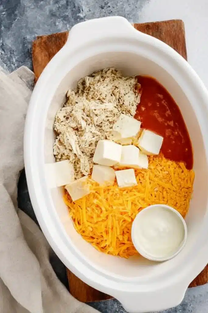 Buffalo Chicken Dip in a Crock Pot ingredients separated in slow cooker before cooking