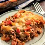 Cheesy Mexican Casserole – Easy, Crowd-Favorite Recipe 6 Cheesy Mexican casserole served on a white plate with melted cheese, beef, and tomatoes