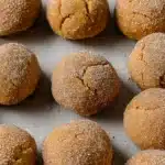 Chewy Maple Pumpkin Cookies – Cozy & Irresistible Treat 10 Chewy maple pumpkin cookies coated in spiced sugar, arranged on a parchment-lined baking sheet ready to bake.