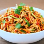 Chinese Chicken Breast Salad (Quick & Flavorful Recipe) 10 Chinese Chicken Breast Salad with shredded chicken, crisp vegetables, peanuts, and spicy sesame chili dressing in a white bowl