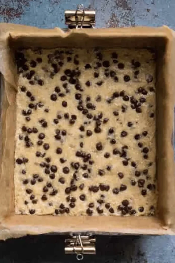 Chocolate Chip Banana Bars 7 Square pan with unbaked chocolate chip banana bar batter and chocolate chips on top