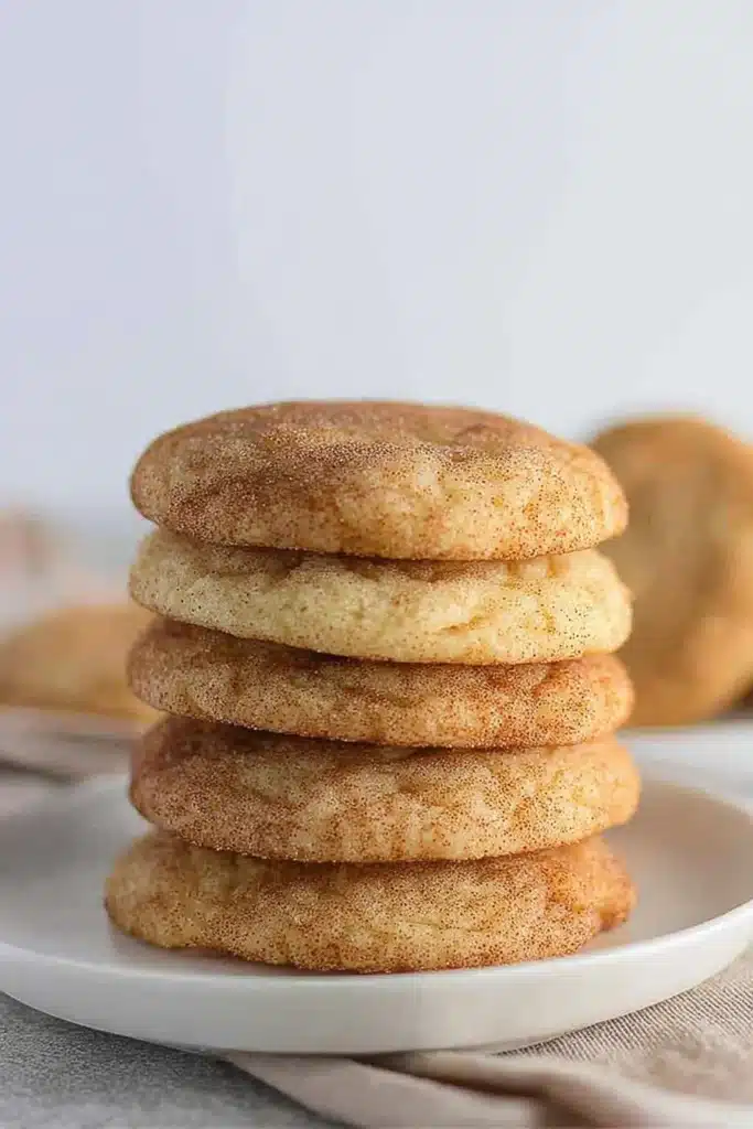 Stack of classic cinnamon snickerdoodle cookies on a white plate with a soft background