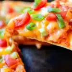 Copycat Taco Bell Mexican Pizzas | Easy & Tasty Dinner 6 Copycat Taco Bell Mexican Pizzas slice with melted cheese, tomatoes, and green onions on a crispy tortilla being lifted from a whole pizza