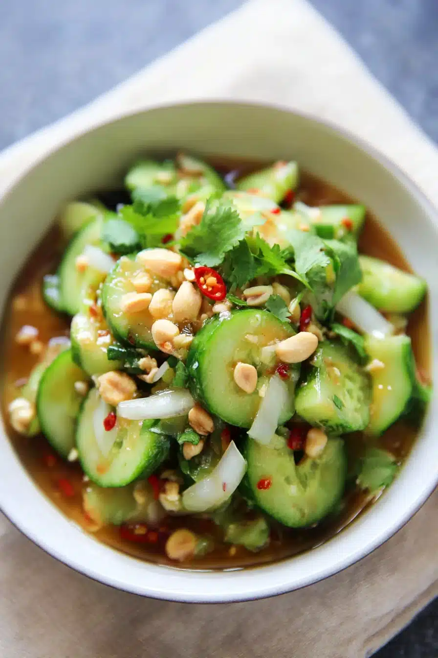 Colorful Thai cucumber salad with peanuts, onions, and herbs in sweet chili dressing.