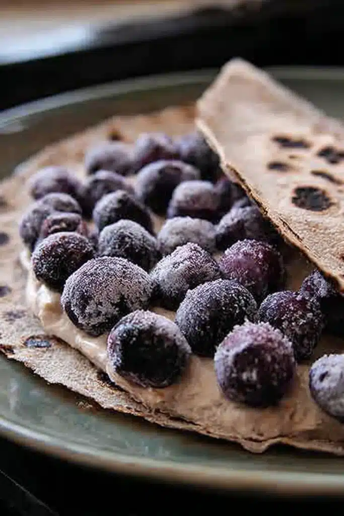 Frozen blueberries on creamy cheese spread over a whole wheat tortilla
