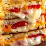 Garlic Bread Grilled Cheese Recipe | Amazing & Quick Lunch 7 Stacked garlic bread grilled cheese sandwich with golden crispy crust, melted cheddar and provolone cheese, and fresh tomatoes.
