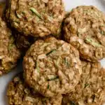 Healthy Zucchini Oatmeal Cookies | Soft, Cozy Treat 10 Healthy zucchini oatmeal cookies with rustic texture, golden-brown color, soft chewy surface, and visible green zucchini flecks on a white plate