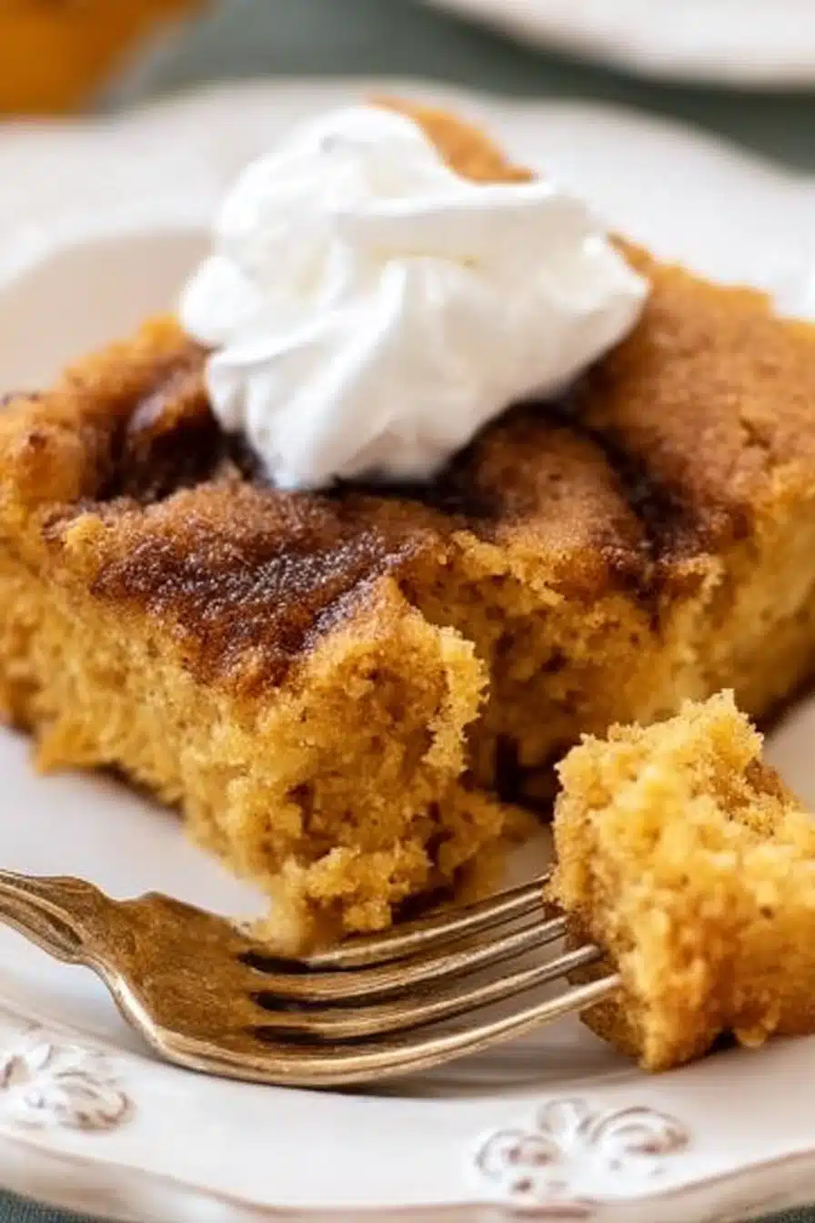 Moist slice of keto pumpkin cake with whipped cream on a plate and fork