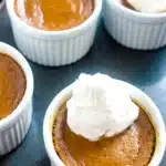 Mini Keto Crustless Pumpkin Pie topped with whipped cream in a white ramekin