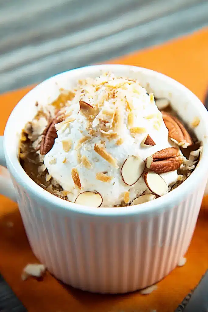 Mini Keto Crustless Pumpkin Pie topped with whipped cream, coconut, and pecans in a white ramekin
