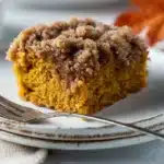 Easy Pumpkin Coffee Cake 8 Close-up of a slice of moist pumpkin coffee cake with cinnamon crumb topping on a cream plate