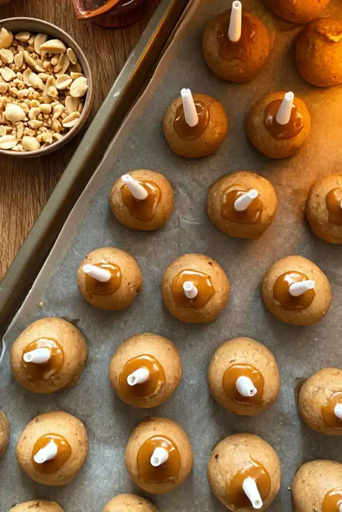 Caramel Apple Donut Cake Pops – Easy & Fun Fall Treat 7 Caramel Apple Donut Cake Pops on tray with sticks and caramel before coating