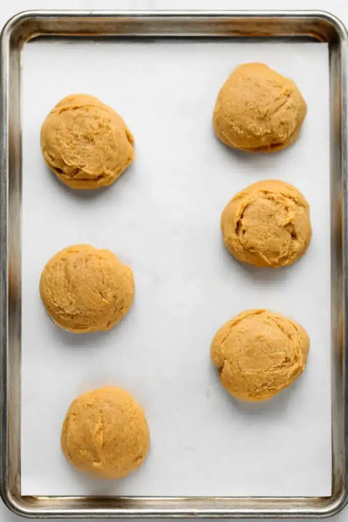 Pumpkin Cheesecake Cookies – Soft, Creamy & Irresistible 10 Unbaked pumpkin cheesecake cookie dough mounds on parchment-lined tray
